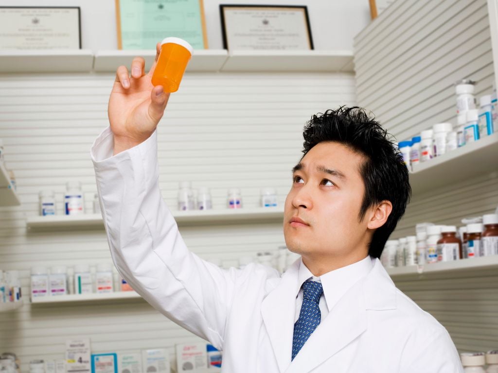 a pharmacist holding up an empty pill bottle, adderall shortage with no medication